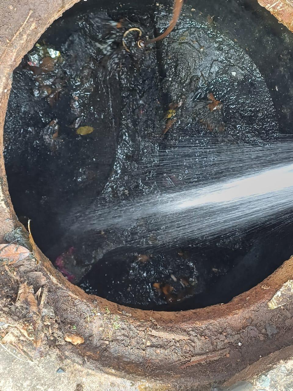High-pressure water jet cleaning an underground manhole